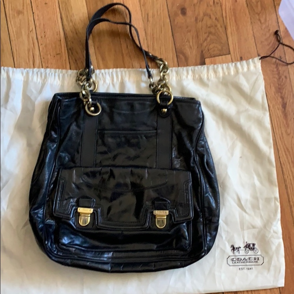 Black coach bag with gold straps and pink lining